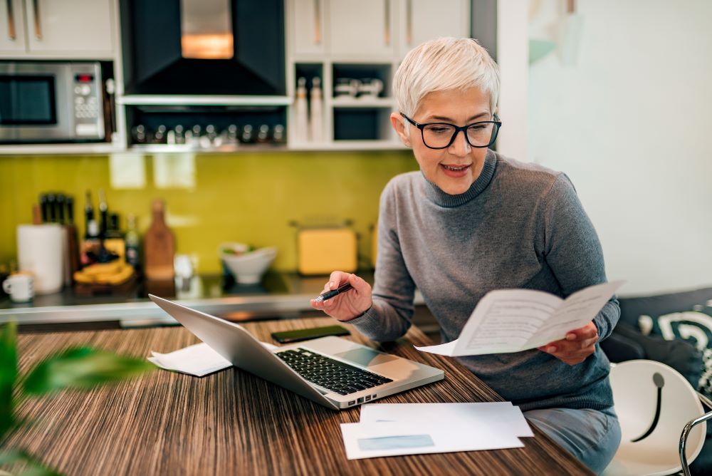 Senior woman doing paperwork at home.