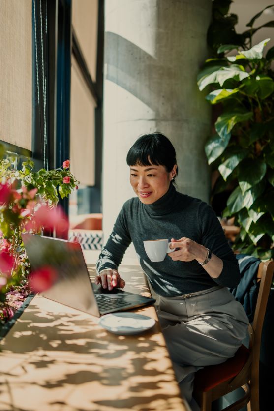 Woman smiling while looking at the laptop in a cafe